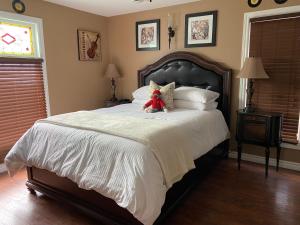 a teddy bear sitting on a bed in a bedroom at Inn136 Guest House in Kingsville