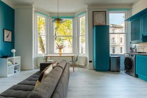 a living room with blue cabinets and a couch at Newly Renovated Central Modern Apartment in Brighton & Hove