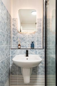 a bathroom with a white sink and a mirror at Newly Renovated Central Modern Apartment in Brighton & Hove