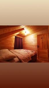 sypialnia z łóżkiem w drewnianym pokoju w obiekcie Vikendica MM Kolasin w mieście Kolašin