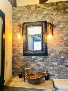 ein Badezimmer mit einem Waschbecken und einem Spiegel an einer Backsteinwand in der Unterkunft RUSTIK Hermoso Rinconcito olivo(5 min centro) in Valle de Bravo + 4 Fotos