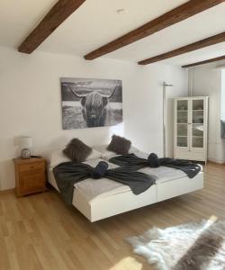 ein Schlafzimmer mit einem Bett und einem Bild einer Kuh in der Unterkunft La Suite in Chur