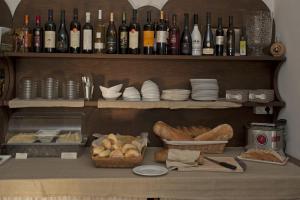 a shelf filled with lots of bottles of wine and bread at Nascar Hotel in Santa Maria Navarrese