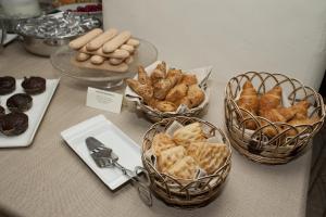 three baskets of bread and pastries on a table at Nascar Hotel in Santa Maria Navarrese