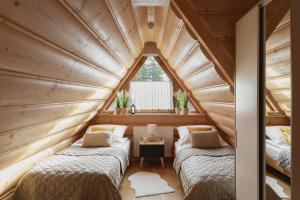 2 łóżka w pokoju na poddaszu z oknem w obiekcie Nimbus w mieście Kościelisko