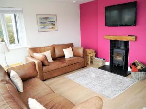 a living room with a couch and a fire place at Firpoint in Rockcliffe