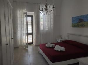 een slaapkamer met een rood bed en 2 handdoeken erop bij Casa Cesira in Casamassella