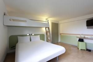 a bedroom with a white bed and white walls at ibis budget Tarbes in Tarbes