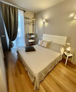 1 dormitorio con 1 cama blanca grande frente a una ventana en Piccola Dimora B&B, en Lucca