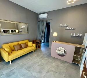 sala de estar con sofá amarillo y mesa en Piccola Dimora B&B, en Lucca