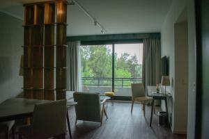 un soggiorno con tavolo, sedie e una grande finestra di KOS Pilar Hotel a Pilar