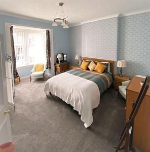 a bedroom with a bed and a chair and a window at St John's Flat Spacious Accomodation in Dalry