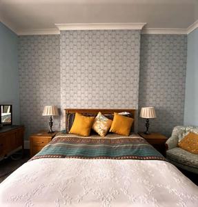 ein Schlafzimmer mit einem Bett, zwei Lampen und einem Sofa in der Unterkunft St John's Flat Spacious Accomodation in Dalry