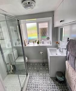 een badkamer met een douche en een wastafel bij St John's Flat Spacious Accomodation in Dalry