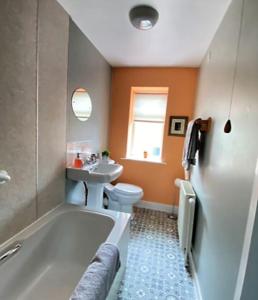 een badkamer met een bad, een toilet en een wastafel bij St John's Flat Spacious Accomodation in Dalry