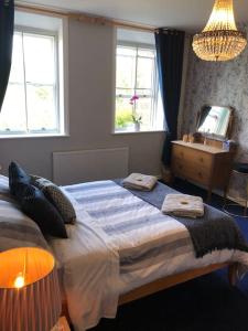 a bedroom with a large bed and two windows at Escape To The Country @ Bron Offa Bach in Coedpoeth