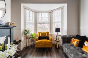 a living room with a yellow chair and a couch at The Crescent Townhouse in Lisburn