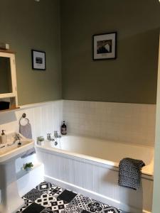 a bathroom with a bath tub and a sink at Escape To The Country @ Bron Offa Bach in Coedpoeth