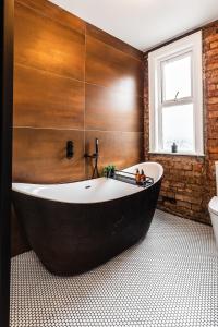 a large black tub in a bathroom with a window at The Crescent Townhouse in Lisburn