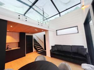 a living room with a black couch and a glass ceiling at Arctic Iglu Levi in Levi