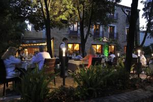 a group of people sitting at tables at a restaurant at Nascar Hotel in Santa Maria Navarrese