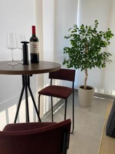 una botella de vino sentada en una mesa con una planta en Lindo Apartamento com banheira e linda vista a 500 m do Capivari, en Campos do Jordão