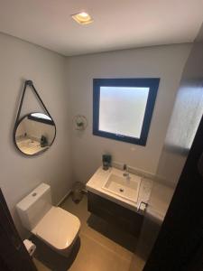 y baño con aseo, lavabo y espejo. en Lindo Apartamento com banheira e linda vista a 500 m do Capivari, en Campos do Jordão
