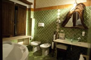a bathroom with a toilet and a sink and a tub at Nascar Hotel in Santa Maria Navarrese