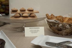a plate of cookies on a table with a basket of bread at Nascar Hotel in Santa Maria Navarrese