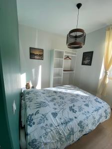 a bedroom with a bed with a blue and white comforter at Le Côté Cour in Barcelonnette