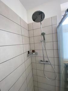 a shower with a shower head in a bathroom at Le Côté Cour in Barcelonnette