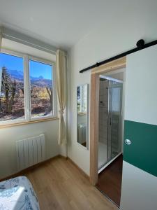 a bathroom with a shower and a glass door at Le Côté Cour in Barcelonnette