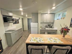 uma cozinha com uma mesa de madeira e uma cozinha com electrodomésticos brancos em Super-modern 1-Bedroom Home Near Downtown SLC em Salt Lake City