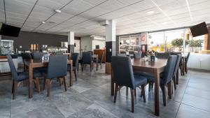 a dining room with wooden tables and chairs at Hotel Plaza Regina Torreon in Torreón