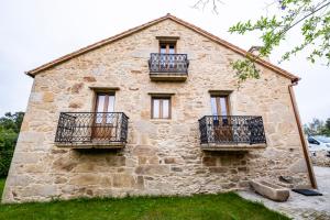 a stone house with balconies on the side of it at Casa Rural Laxido in Rianjo