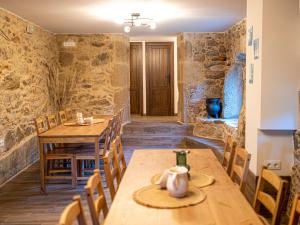 comedor con mesas y sillas de madera en Casa Rural Laxido, en Rianjo