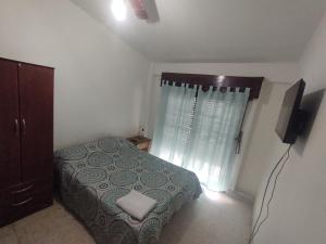 Un dormitorio con una cama y una cómoda y una ventana. en Hostal Nazar, en Salta