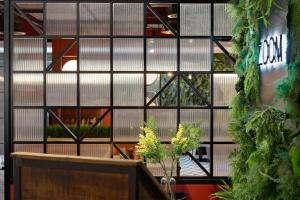 a wall of windows in a building with plants at Hyatt Place London City East in London