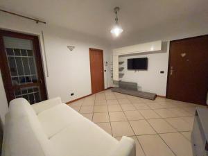 een woonkamer met een witte bank en een televisie bij Ci-Ra's home a Cernusco S/N (MI) in Cernusco sul Naviglio