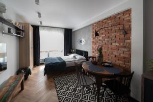 um quarto com uma cama e uma parede de tijolos em Arte Apartments - Old Town Gdańsk em Gdansk