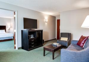 a living room with a couch and a tv at Hotel One75 in Hamilton