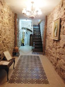 un couloir avec un mur en pierre et un lustre dans l'établissement las llaves del arca, à Trujillo