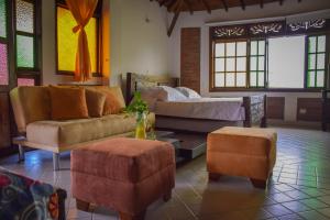 - un salon avec un canapé, un lit et un pouf dans l'établissement Finca Hotel Casa Nostra, Villa Manuela, à Quimbaya