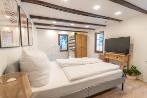 a bedroom with a bed and a flat screen tv at Charmantes denkmalgeschütztes Tiny House am Rhein in Rhens