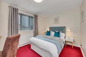 a bedroom with a large bed and a window at The Cambridgeshire in Newmarket