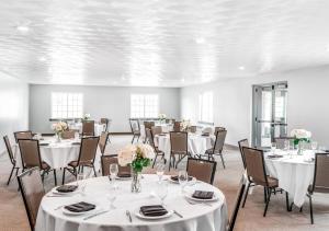 une salle avec tables et chaises et nappes blanches dans l'établissement Hotel One75, à Hamilton