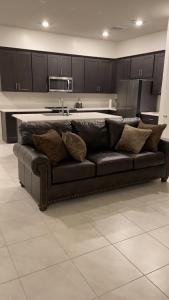 a couch in a living room with a kitchen at AZ Chandler Rental in Chandler