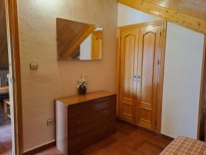 1 dormitorio con vestidor y armario de madera en La alacena de Jose y Rosi, en Güéjar-Sierra