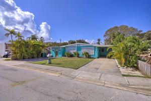 una casa azul con palmeras delante en Cute and Cozy Florida Duplex Walk to Beaches!, en Cocoa Beach