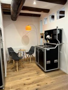 Donaublick Apartment في باساو: مطبخ مع موقد وكراسي وطاولة